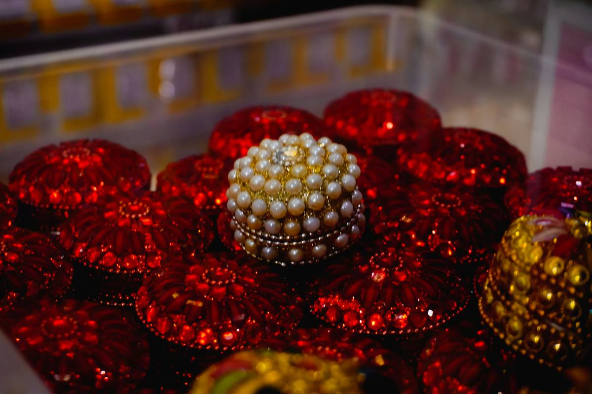 Small decorative jewelry boxes arranged on a wooden dresser with velvet lining visible and gold accents